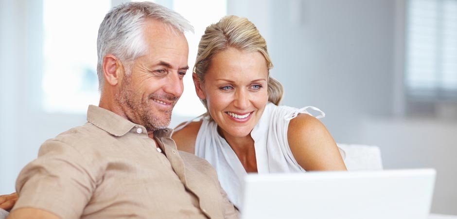Older couple smiling at computer